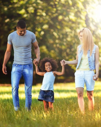 Happy young couple spending time with their daughter in nature